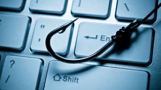 Un anzuelo sobre el teclado de un ordenador representa un ataque de phishing a un sistema informático.