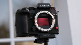 Panasonic Lumix S1R II camera on a tripod outside with no lens attached and the sensor showing