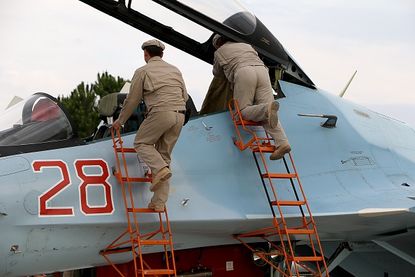 Russia servicemen attend to a plane in Syria.