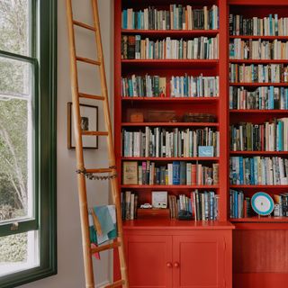 Farrow & Ball Bamboozle red on a bookcase with a window to the left