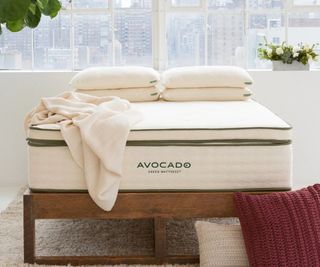 Avocado Organic Latex Mattress Topper on an Avocado Mattress with pillows and a blanket.