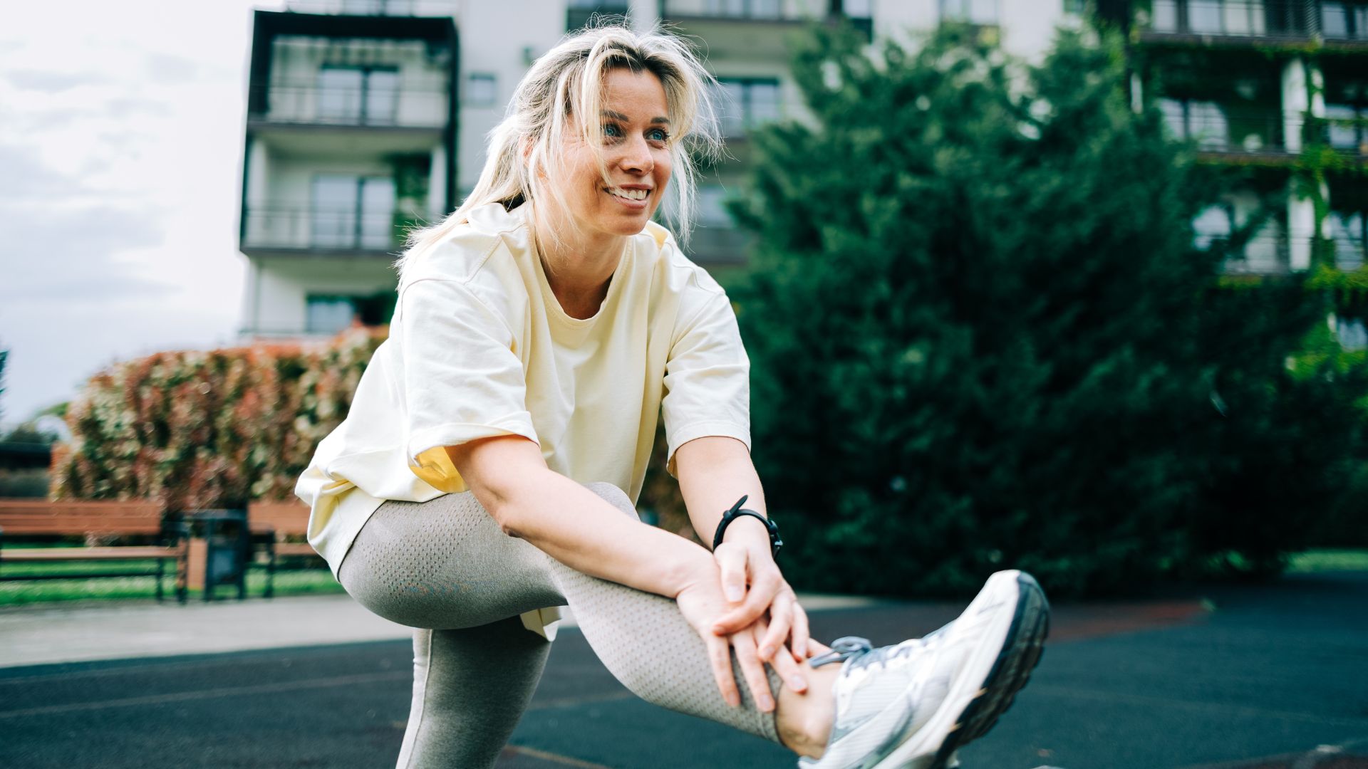 Woman setting up to do lateral leg raises outside