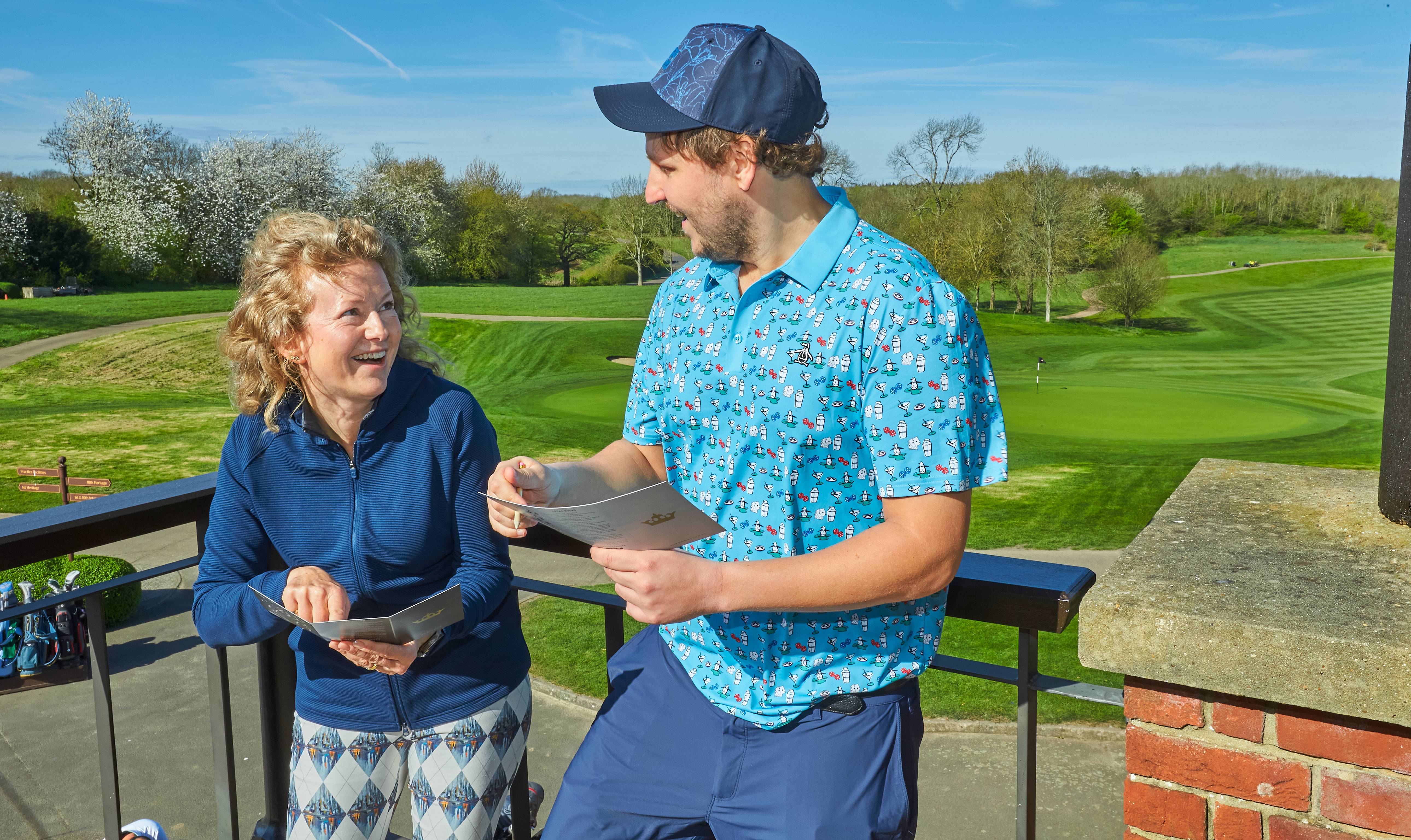 Katie Dawkins and Nick Bonfield laughing at scorecards