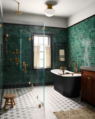 A large bathroom with emerald green wall tiles laid out in different patterns