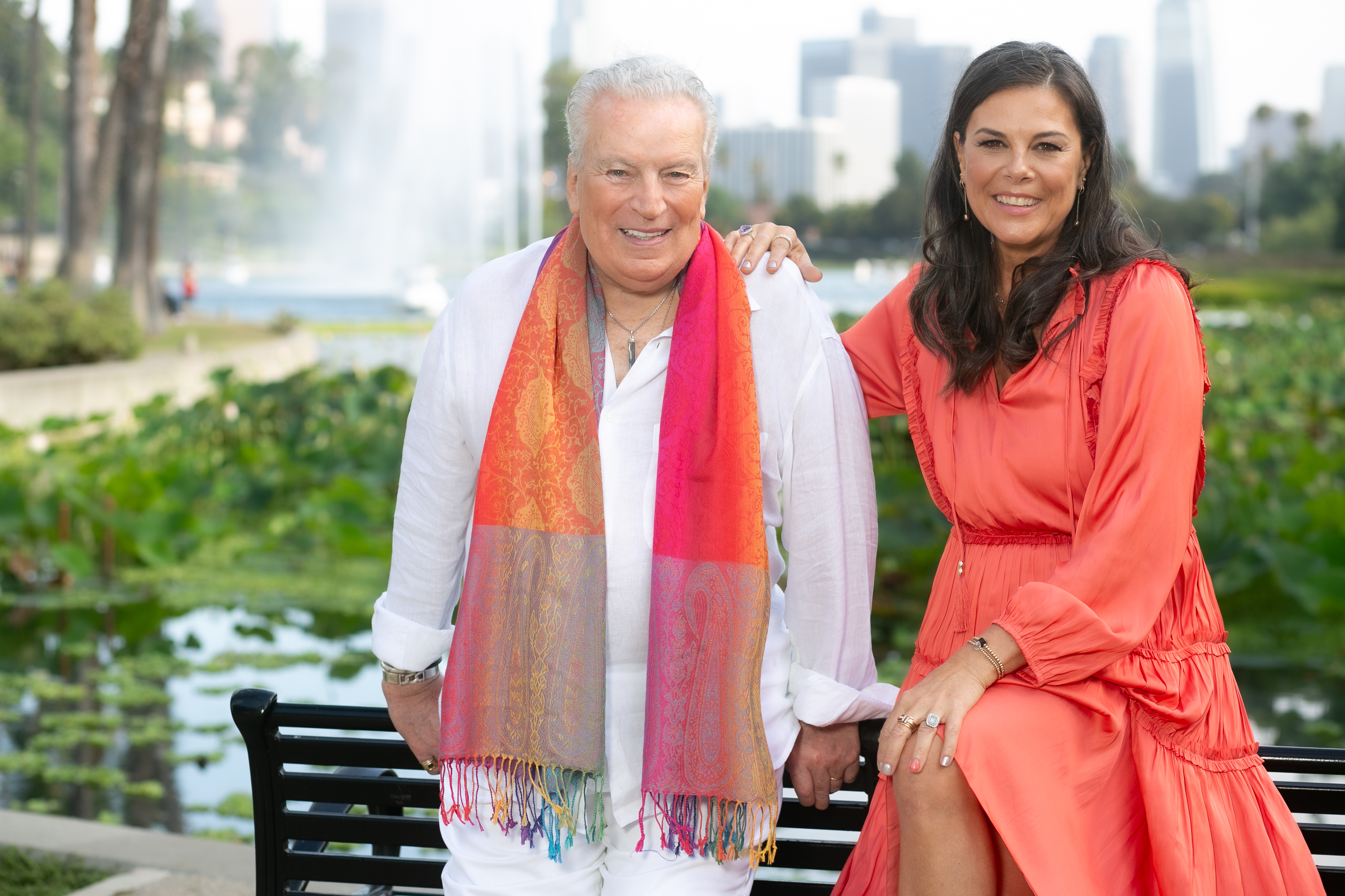 Richard Dalton and Renae Plant posing on a bench with a fountain behind them