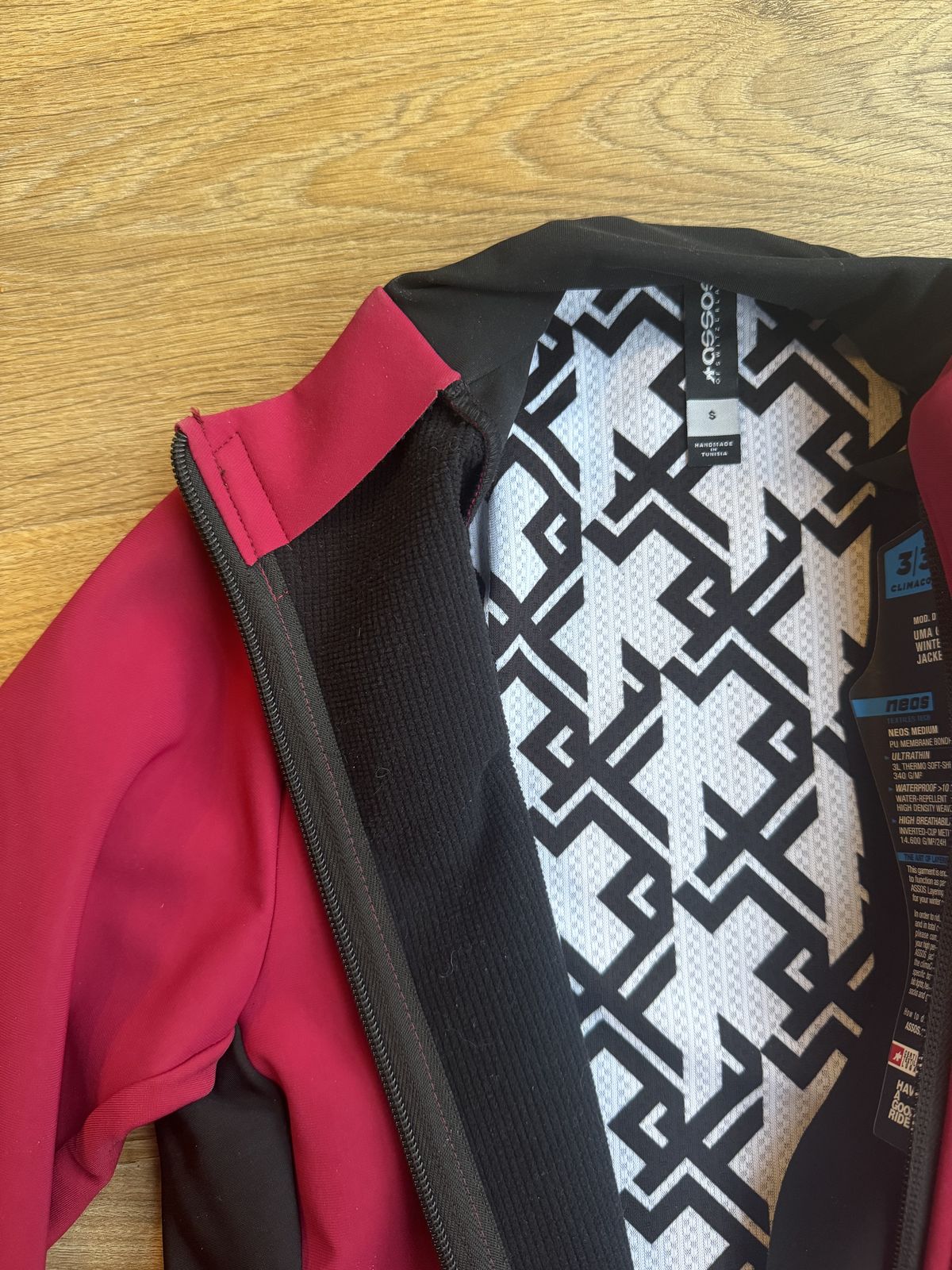 Flat lay of pink jacket with internal showing lots of fabrics and a cool white and black swirl fabric.