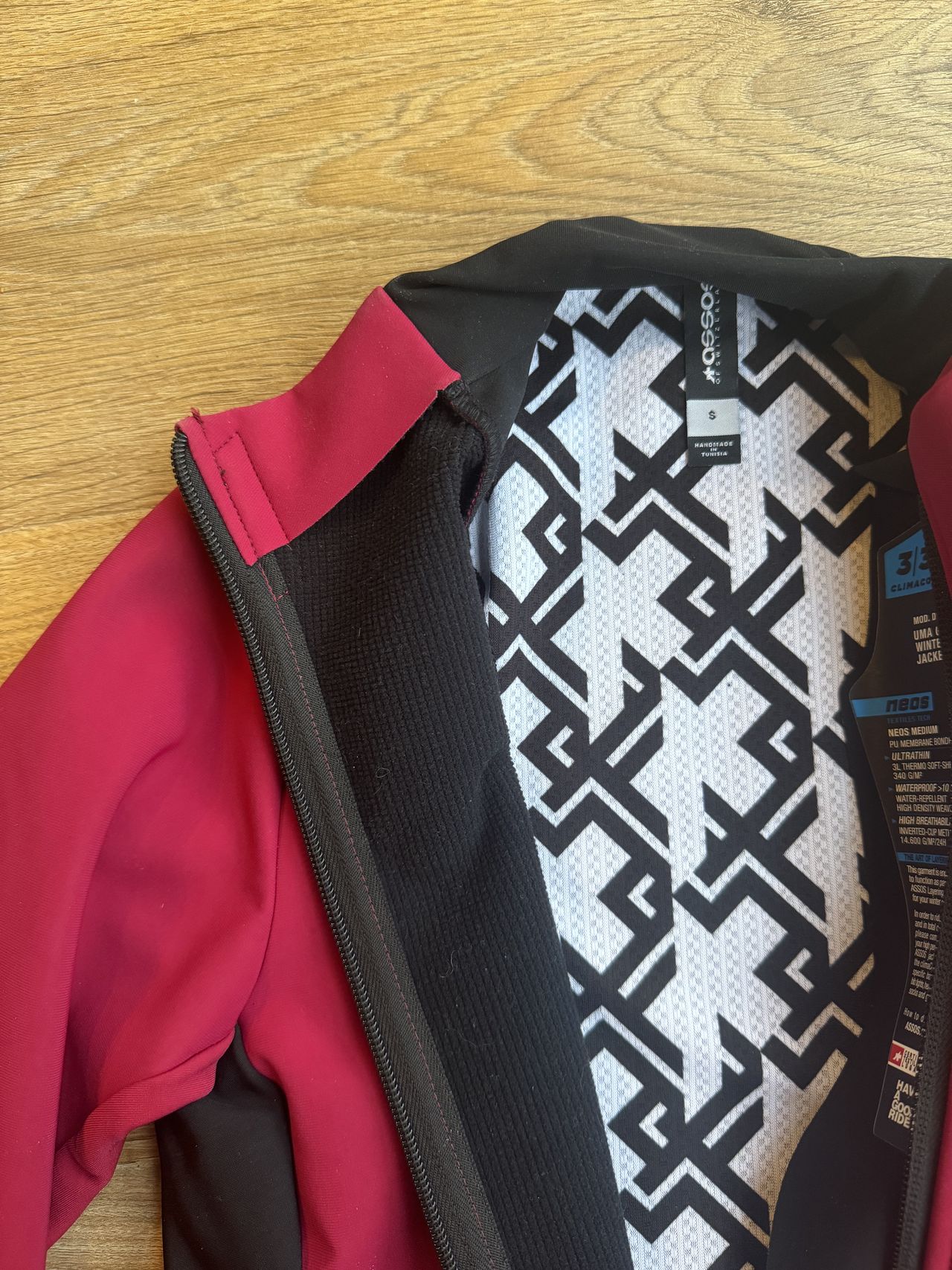 Flat lay of pink jacket with internal showing lots of fabrics and a cool white and black swirl fabric.