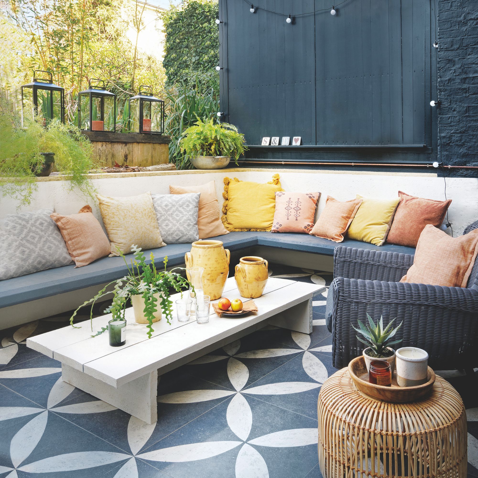 A garden seating zone with large black and white tiled paving underneath