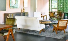 Two white sofas and multiple wooden/grey velvet chairs around tables