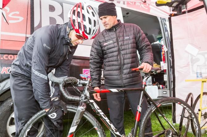Todd Wells checks on his tubeless setup with the crew at the Stan's NoTubes tent