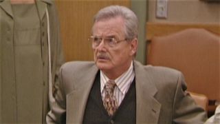 Mr. Feeny sitting behind desk in school court on Boy Meets World