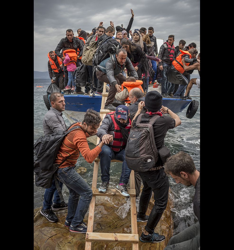 Refugees and Migrants aboard a fishing boat driven by smugglers reach the Greek Island coast of Lesbos 