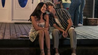 Belly and Jeremiah smiling and sitting next to each other on a porch at night in The Summer I Turned Pretty season 3