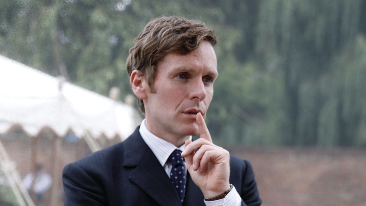 Shaun Evans in a dark suit looks pensive in Endeavour