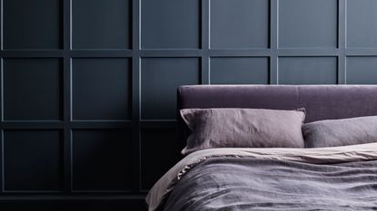 Dark grey panelled wall behind bed