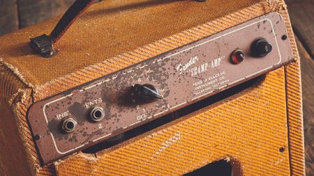 A photo of a vintage Fender Champ amp, showing the back-mounted control panel