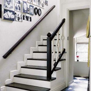 stair case with white wall and picture gallery