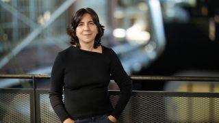 AU 2025; a woman stands in front of a metal railing