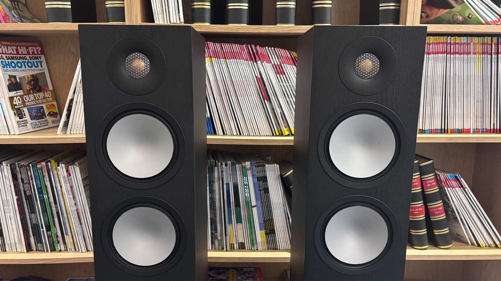 Monitor Audio Bronze 300 7G floorstanding speakers in front of bookcase