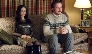 Lars and the Real Girl sit together on the couch