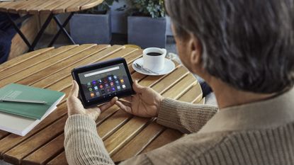 Man using Amazon Fire 7 tablet at table