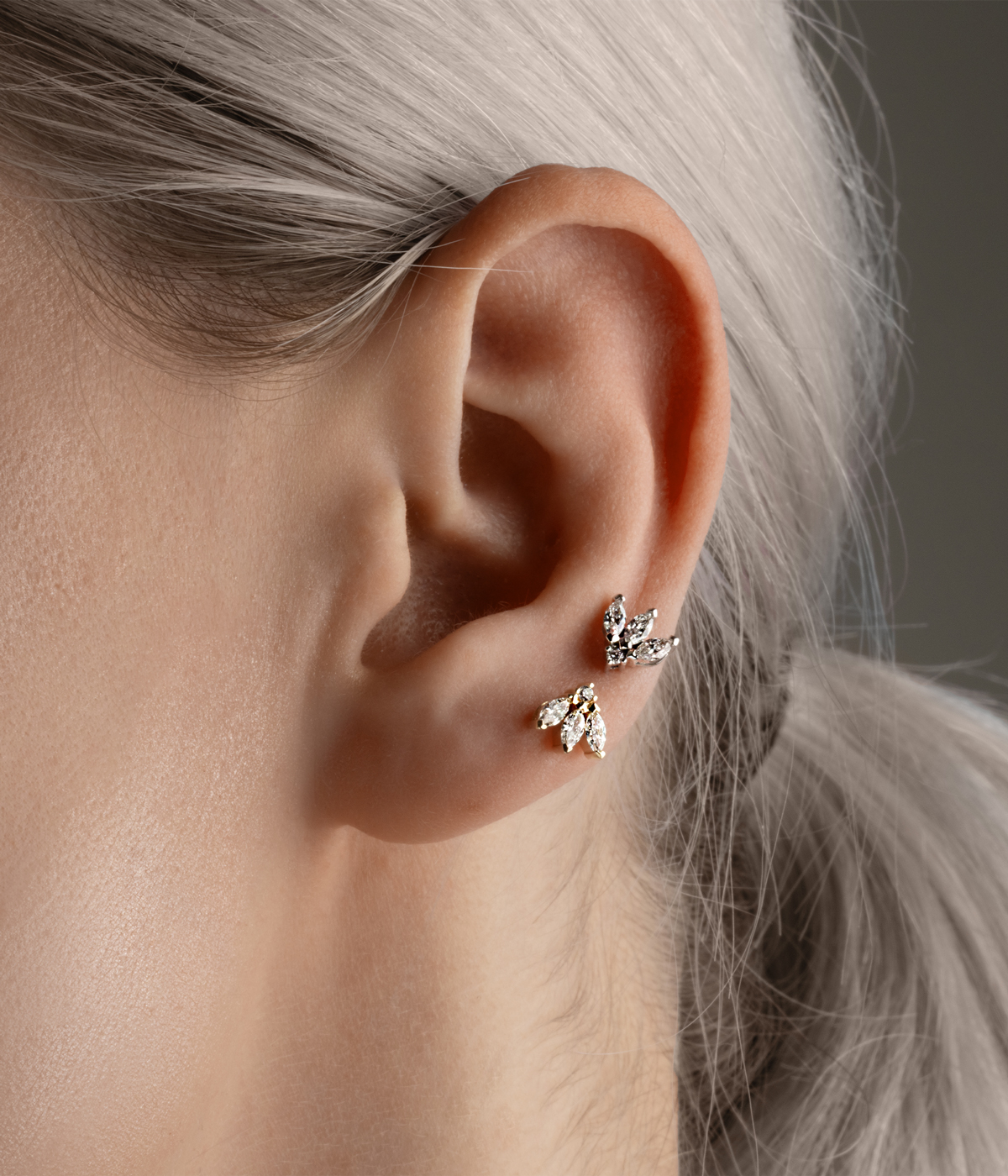side of woman's face with multiple earrings in ear