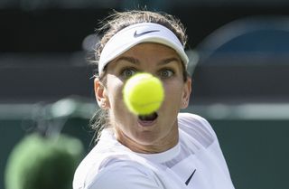 A tennis ball in front of a female player's face