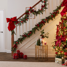 Hallway decorated with red bows, baubles and faux green garlands.