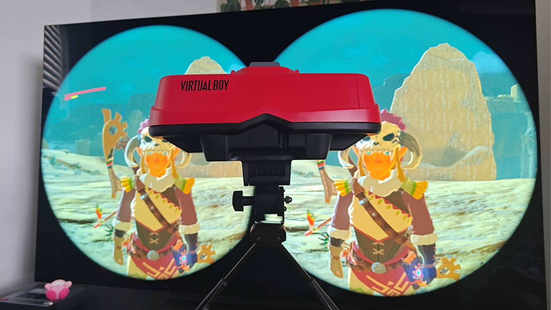 Virtual Boy with TV in background displaying Zelda Breath of the Wild in Nintendo Labo VR mode.