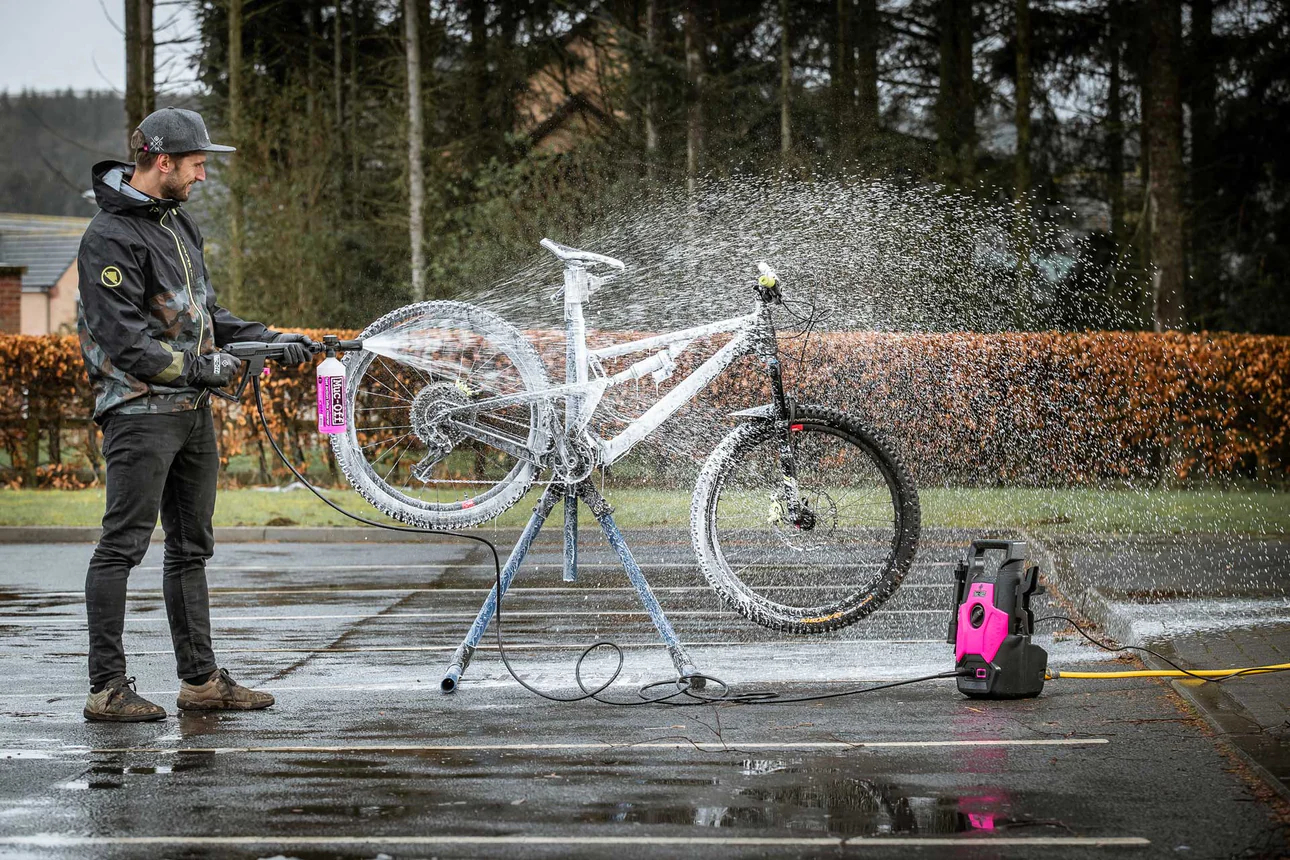 Man cleaning mounting bike outside with Muc-Off Pressure Washer