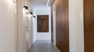 narrow hallway with wall lights and metal wall panels