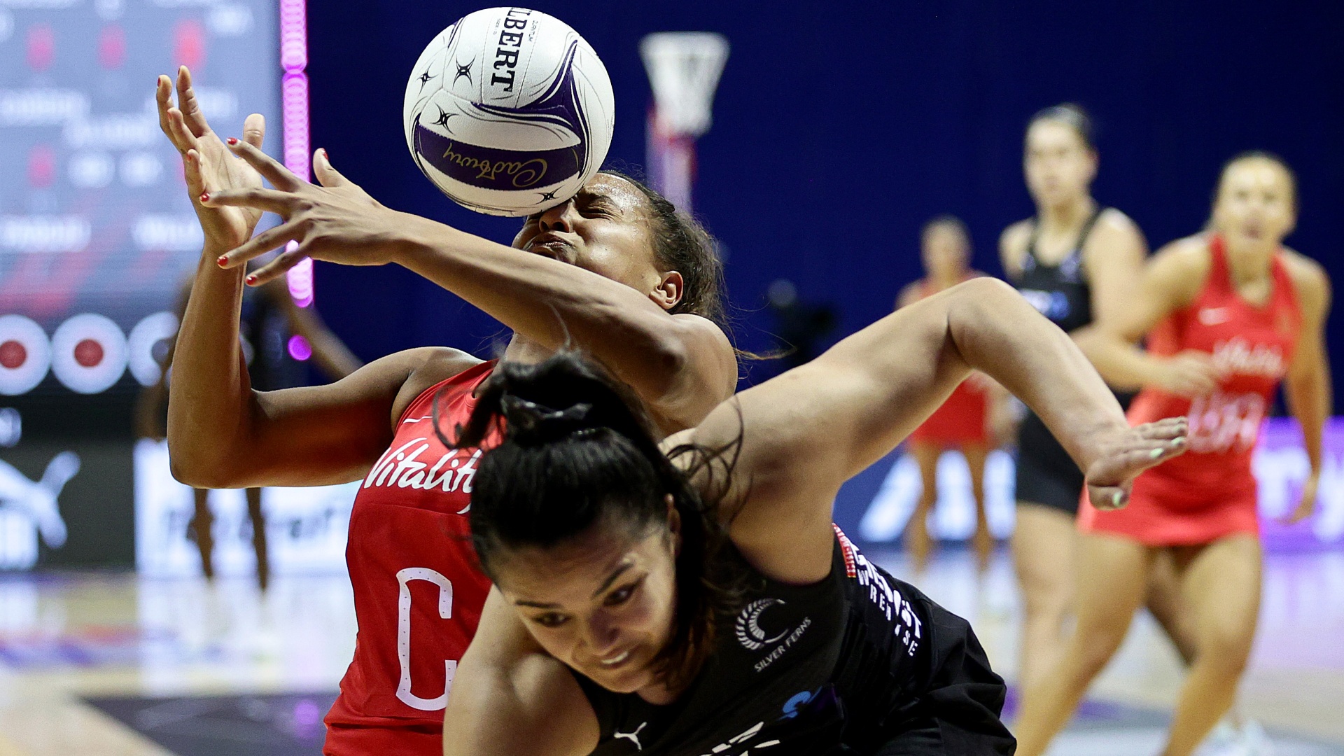 Imogen Allison and Kimiora Poi wrestle for the ball in an England vs New Zealand netball clash