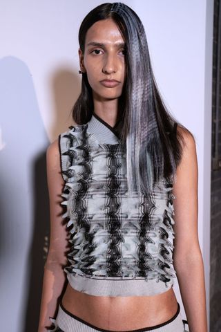 A model backstage at Chet Lo SS25 wearing crimped hair, a key Spring/Summer 2025 Fashion Month beauty look