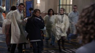 Noah Wyle and Parminder Nagra look back while pushing a hospital bed in the ER series finale.