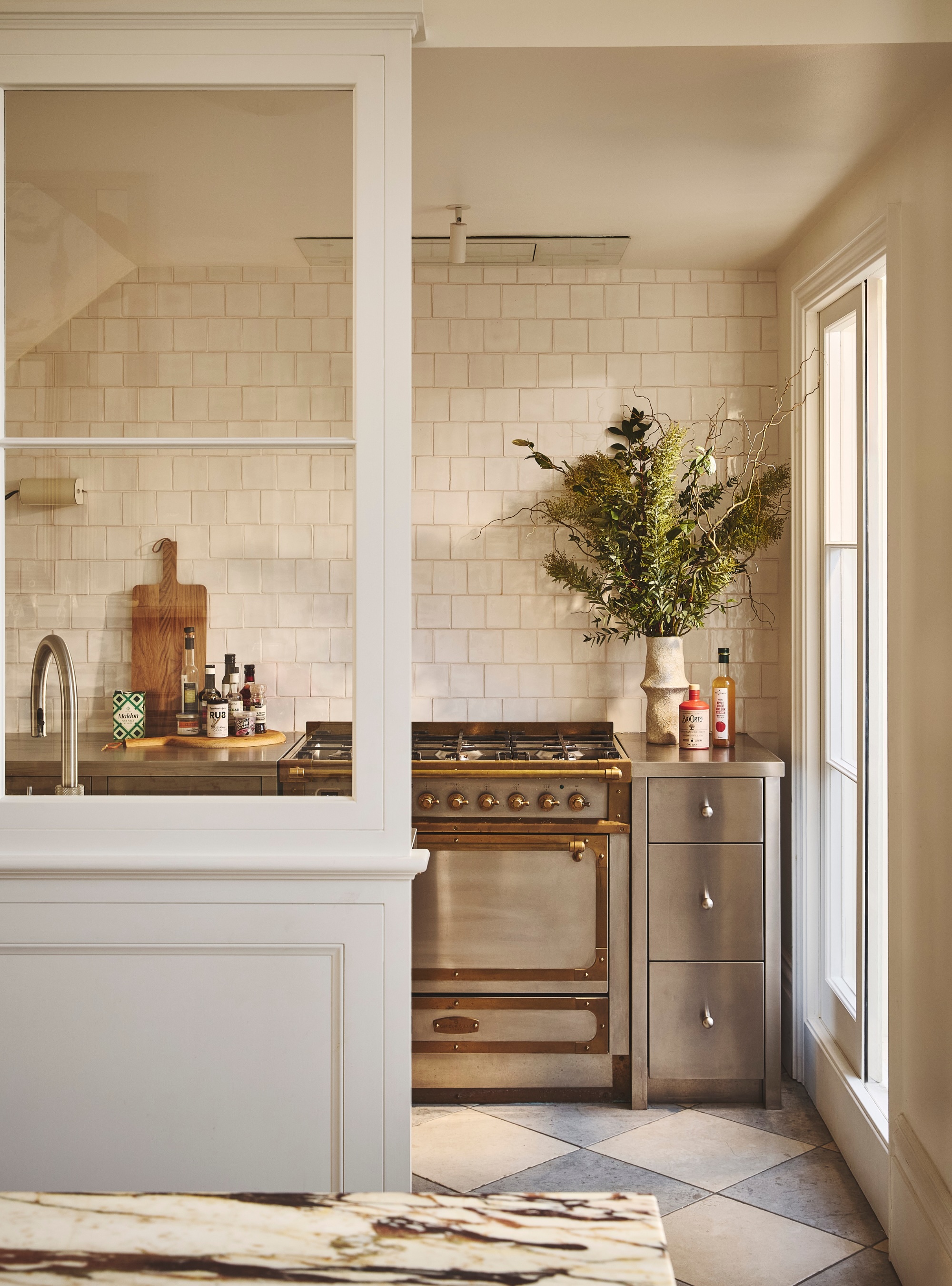 Stainless Steel kitchen with zellige tiles with a checkerboard floor