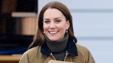 Catherine, Princes of Wales carries takeaway pizza boxes, collected from a pizza van, as she visits Dowlais Rugby Club on April 27, 2023