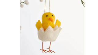 A felt hanging decoration of a chick hatching out of an egg - one of the best Easter decorations