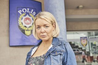 Sheridan Smith as Kathy in No Return, standing outside a Turkish police station in a denim jacket over a floral-patterned black dress, with a look of concern and anxiety on her face