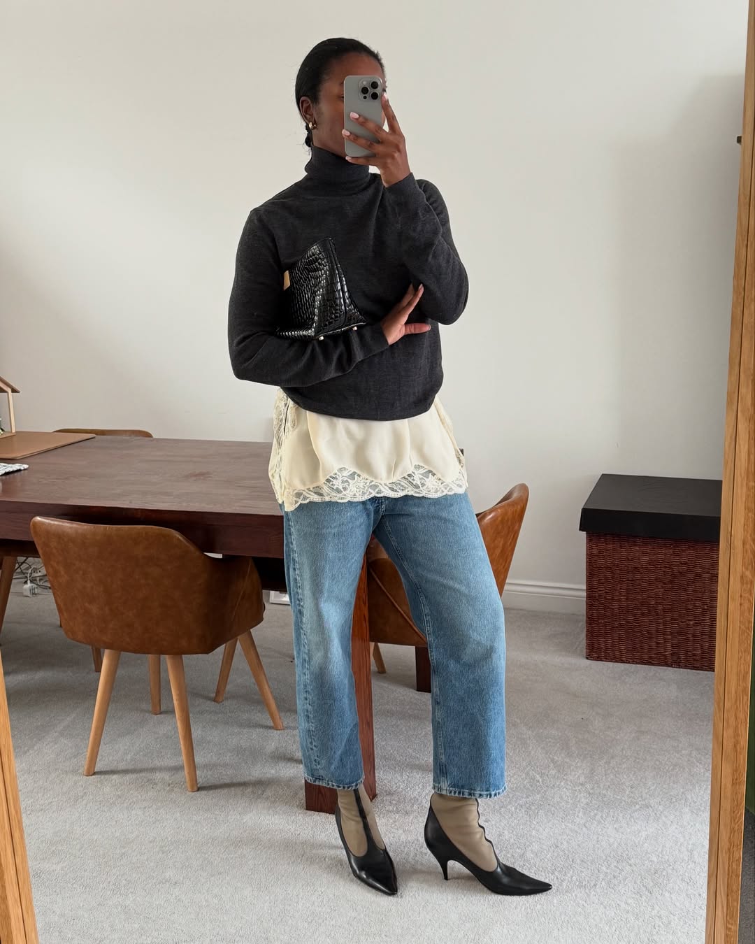 @nlmarilyn wearing a lace-trim tank with jeans and a sweater