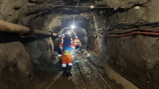Researchers walk down the tunnel of a chromium mine in Albania.