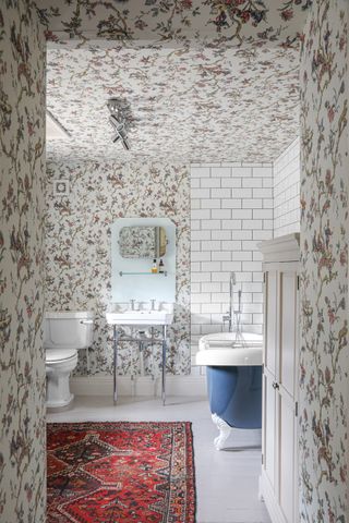 Bathroom with Charlotte Gaisford wallpaper and an antique rug