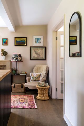 kitchen corner with antique chair and gallery wall with oriental rug