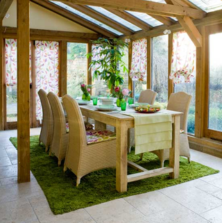 wooden conservatory with green carpet and dining table