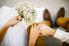 Wedding couple holding hands with bouquet