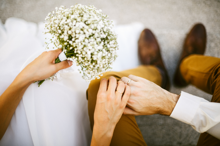 Wedding couple holding hands with bouquet
