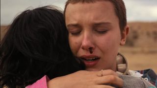 Millie Bobbie Brown as Eleven, hugging Finn Wolfhard as Mike