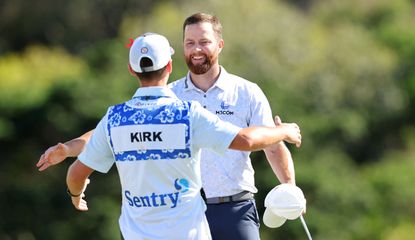 Chris Kirk hugs his caddie on the 18th green after his victory