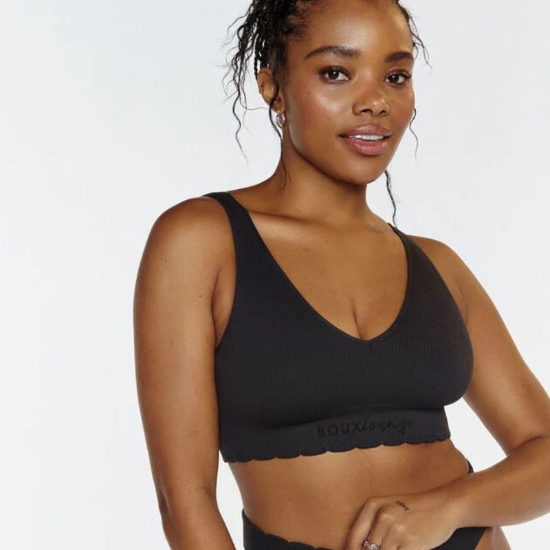 woman wearing a black ribbed bralette with scalloped edge