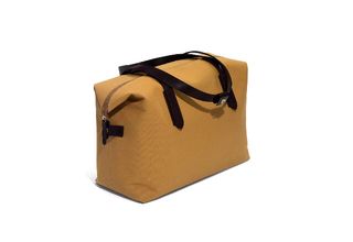 Mismo Luggage, Denmark. A light brown square shaped bag with dark leather straps.