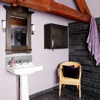 bathroom with dark tiles and washbasin